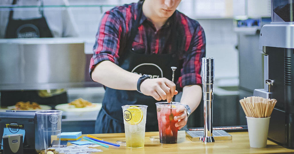 Homem preparando um drink vermelho