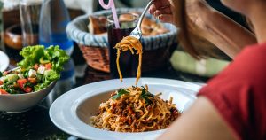 Prato de macarrão com pães em volta