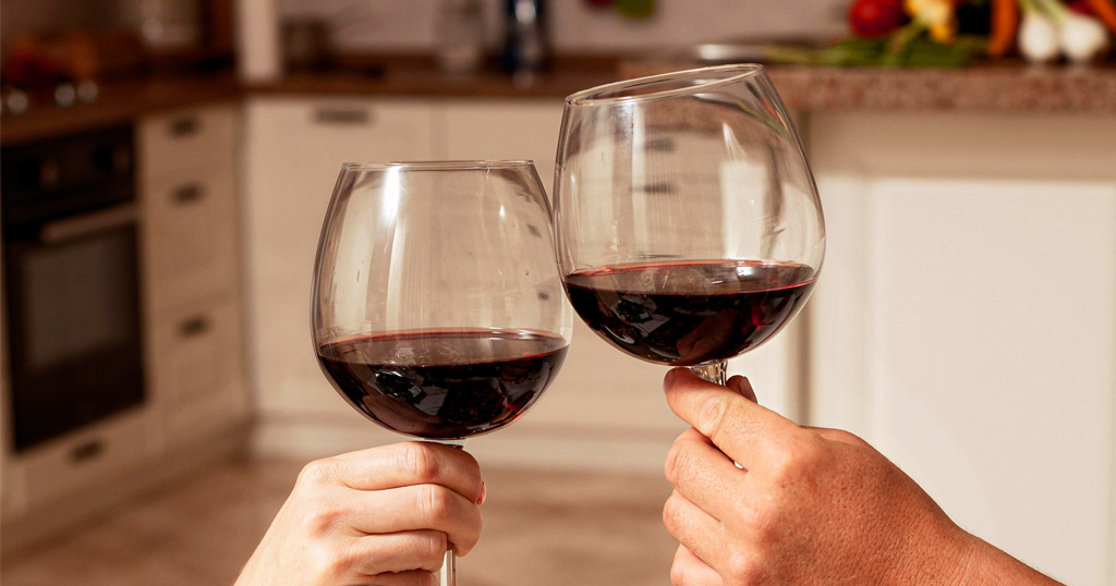 Casal fazendo um brinde com duas taças de vinho